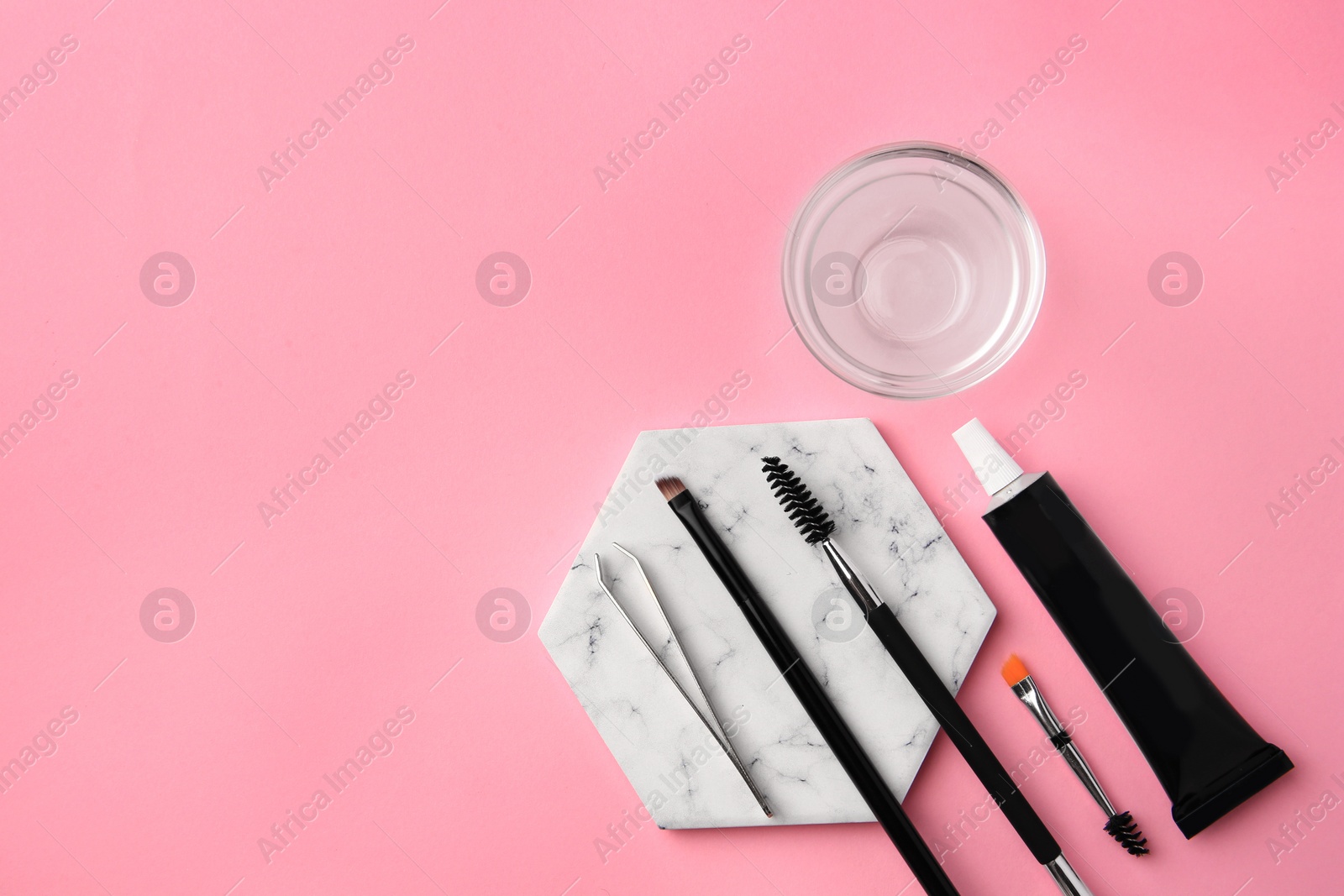 Photo of Flat lay composition with eyebrow henna and tools on pink background. Space for text