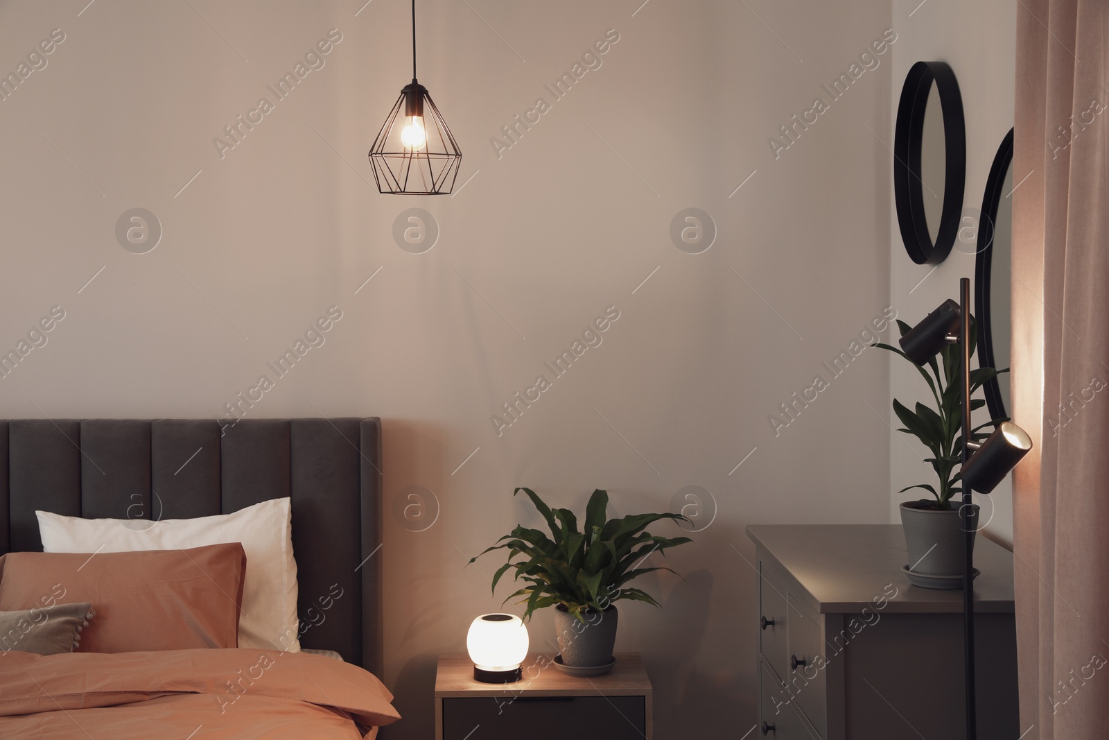 Photo of Stylish bedroom interior with comfortable bed, nightstand and green houseplants