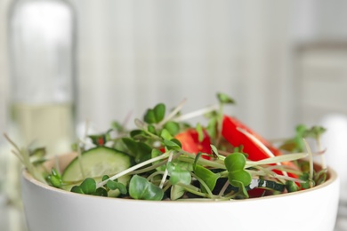 Salad with fresh organic microgreen in bowl indoors, closeup