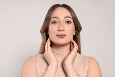 Photo of Young woman with lip piercing on white background