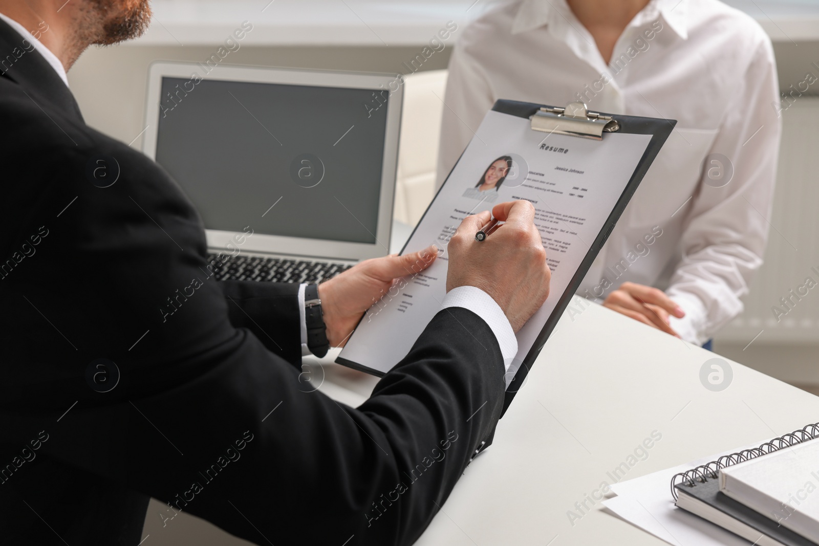 Photo of Human resources manager reading applicant's resume in office, closeup