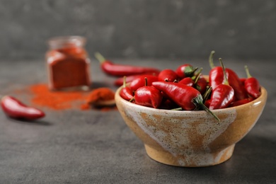 Photo of Red chili peppers in bowl on table. Space for text