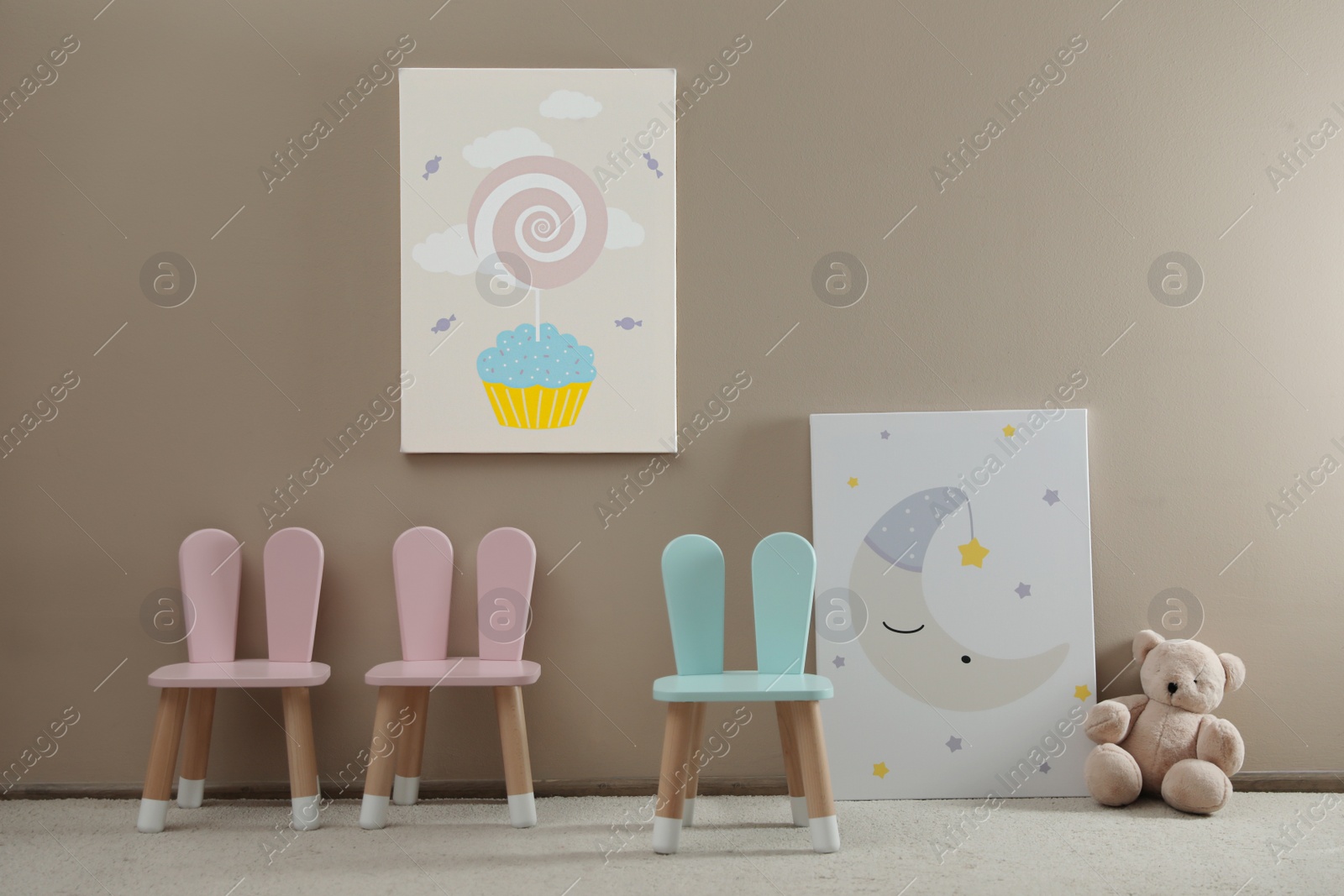 Photo of Cute chairs with bunny ears in children's room interior