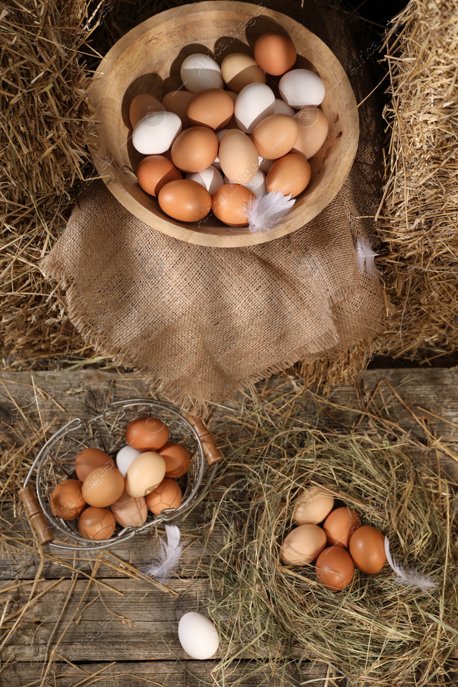 Photo of Fresh chicken eggs and dried straw in henhouse, flat lay