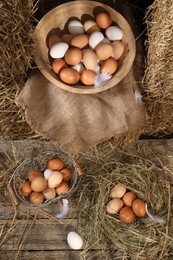 Fresh chicken eggs and dried straw in henhouse, flat lay