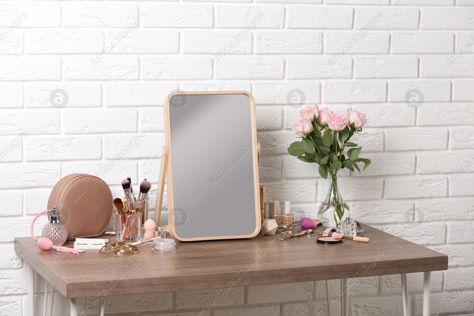 Photo of Dressing table with different makeup products and accessories in room interior