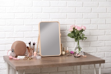 Photo of Dressing table with different makeup products and accessories in room interior