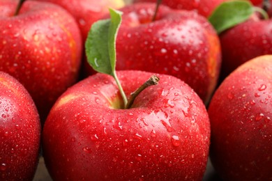 Delicious ripe red apples with water drops as background, closeup