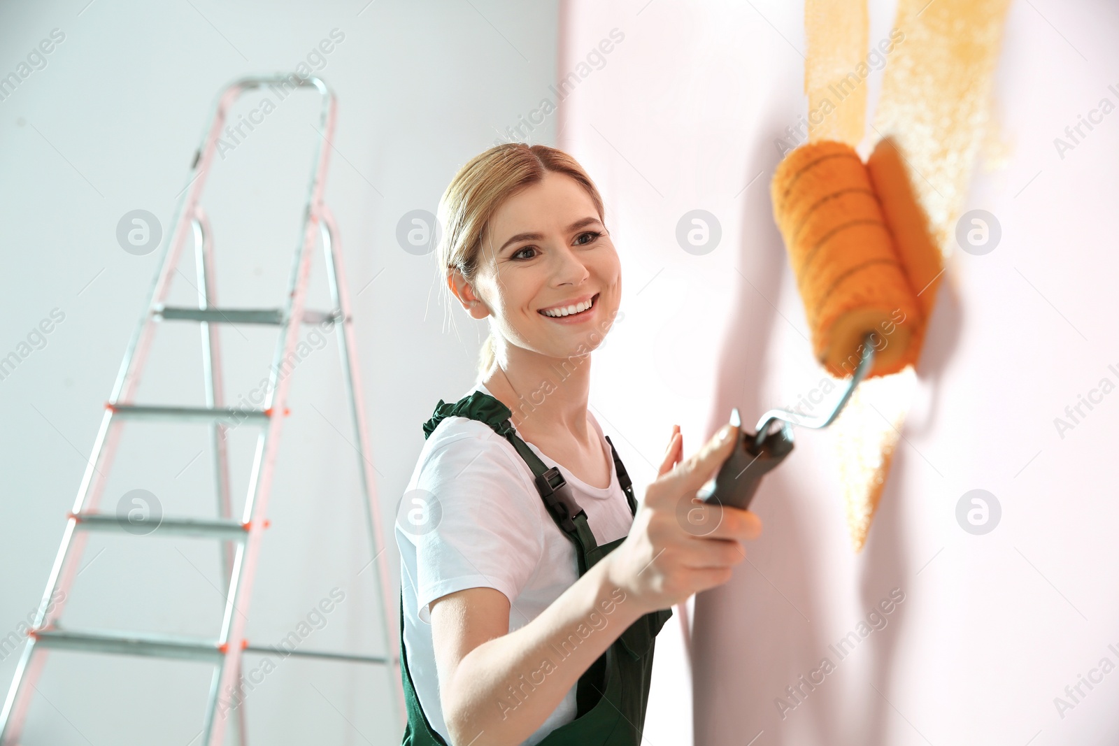 Photo of Professional decorator painting wall indoors. Home repair service