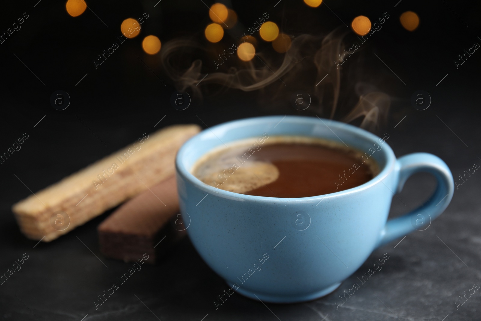 Photo of Delicious coffee and wafers on grey table