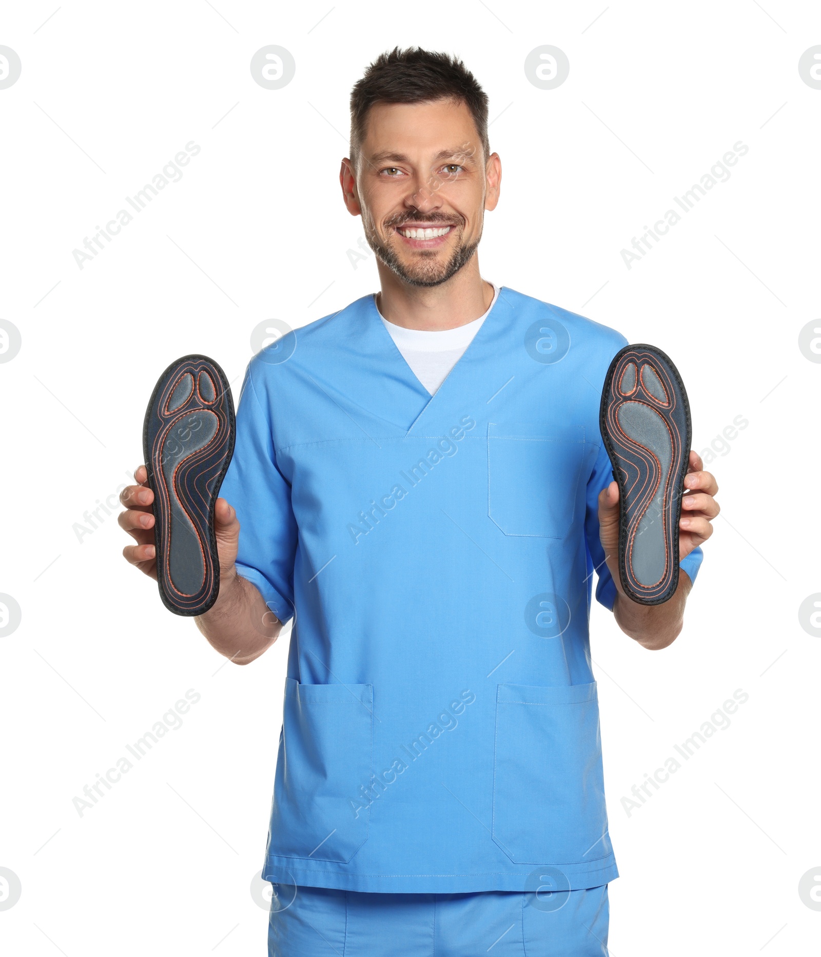 Photo of Handsome male orthopedist showing insoles on white background