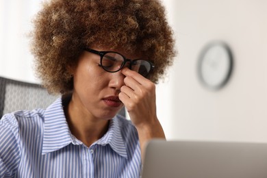 Photo of Woman suffering from headache in office, space for text