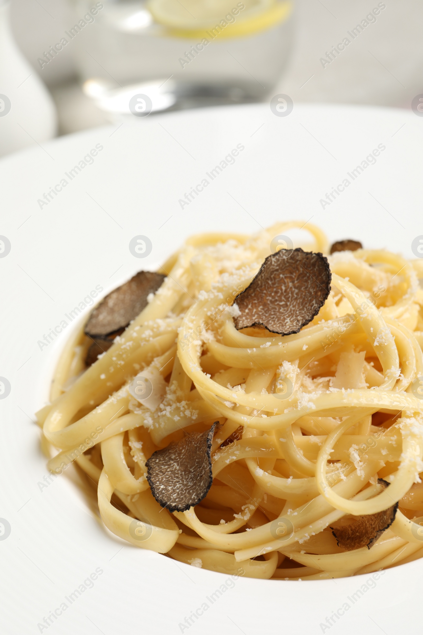 Photo of Delicious pasta with truffle slices and cheese on plate, closeup