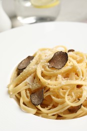 Delicious pasta with truffle slices and cheese on plate, closeup