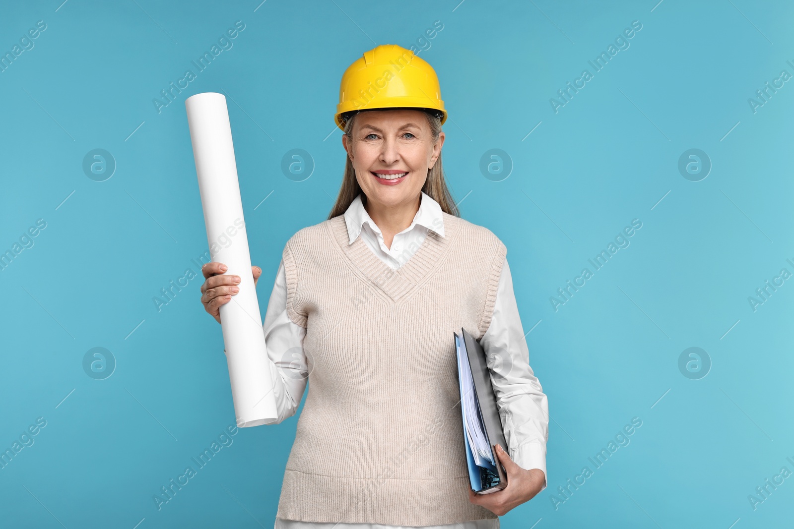 Photo of Architect in hard hat with draft and folder on light blue background