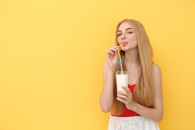 Photo of Young woman with glass of delicious milk shake on color background