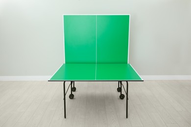 Photo of One folding green ping pong table indoors