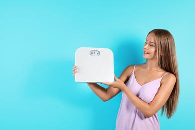 Photo of Slim woman with scale on color background. Healthy diet