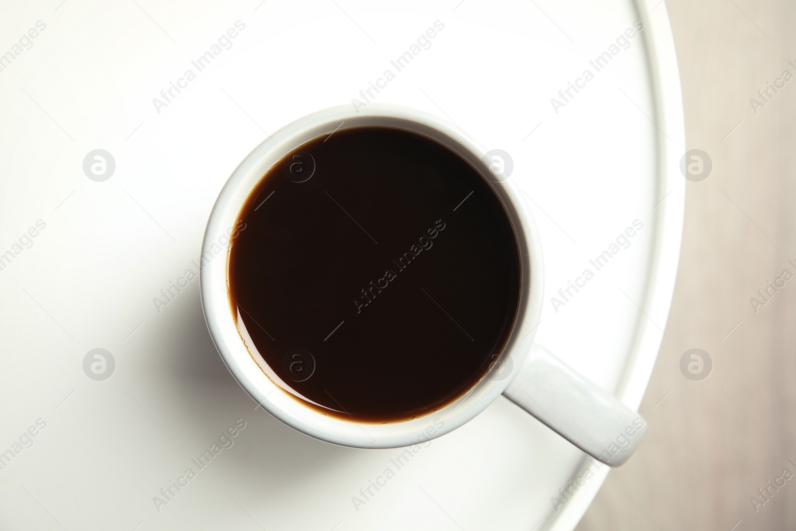 Photo of Cup of fresh aromatic coffee on light table, top view. Food photography