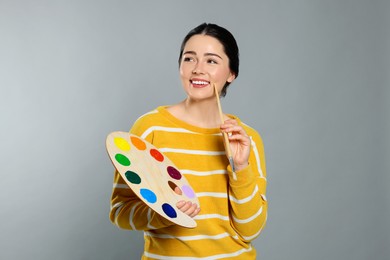 Woman with painting tools on grey background. Young artist