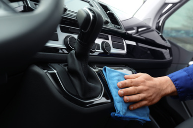 Photo of Car wash worker cleaning automobile interior, closeup