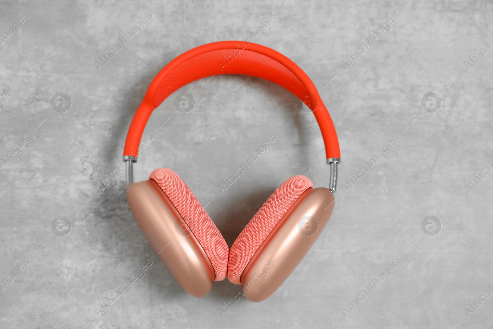 Photo of Stylish pink headphones on light grey table, top view