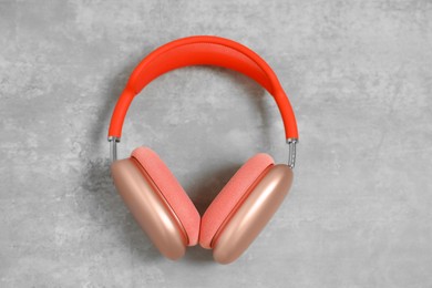 Photo of Stylish pink headphones on light grey table, top view