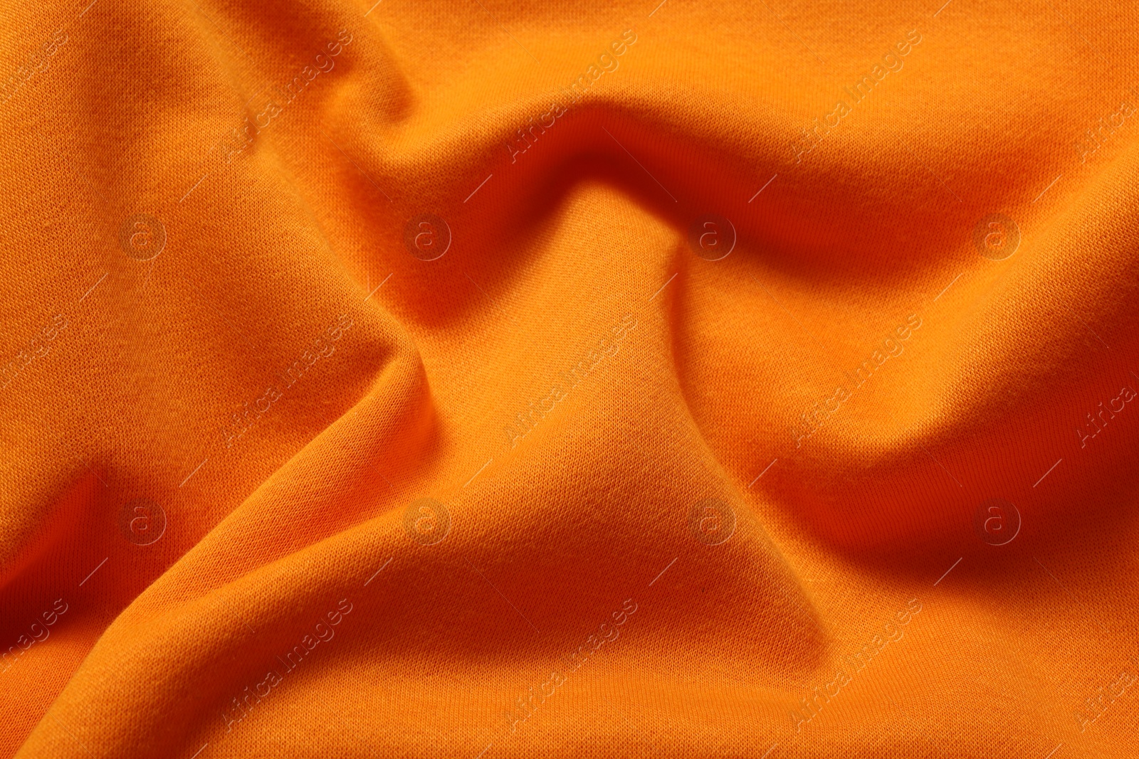 Photo of Texture of orange crumpled fabric as background, top view