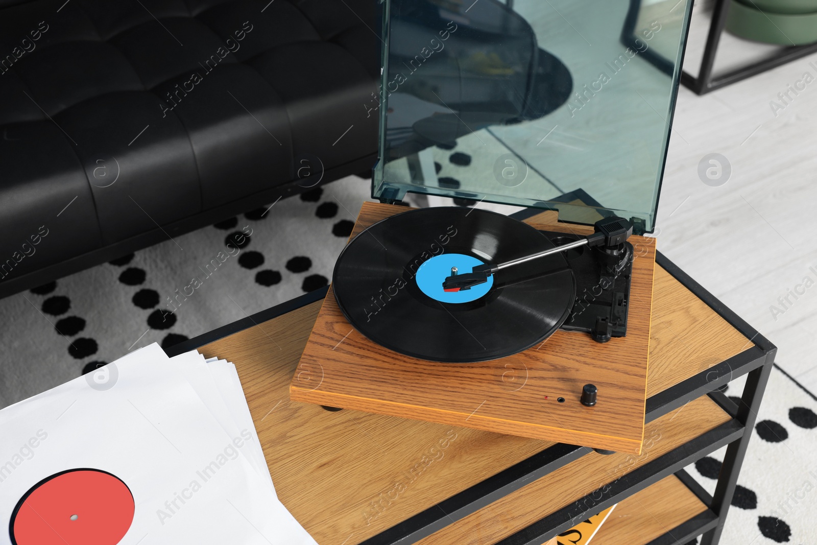 Photo of Vinyl record player on wooden table in living room