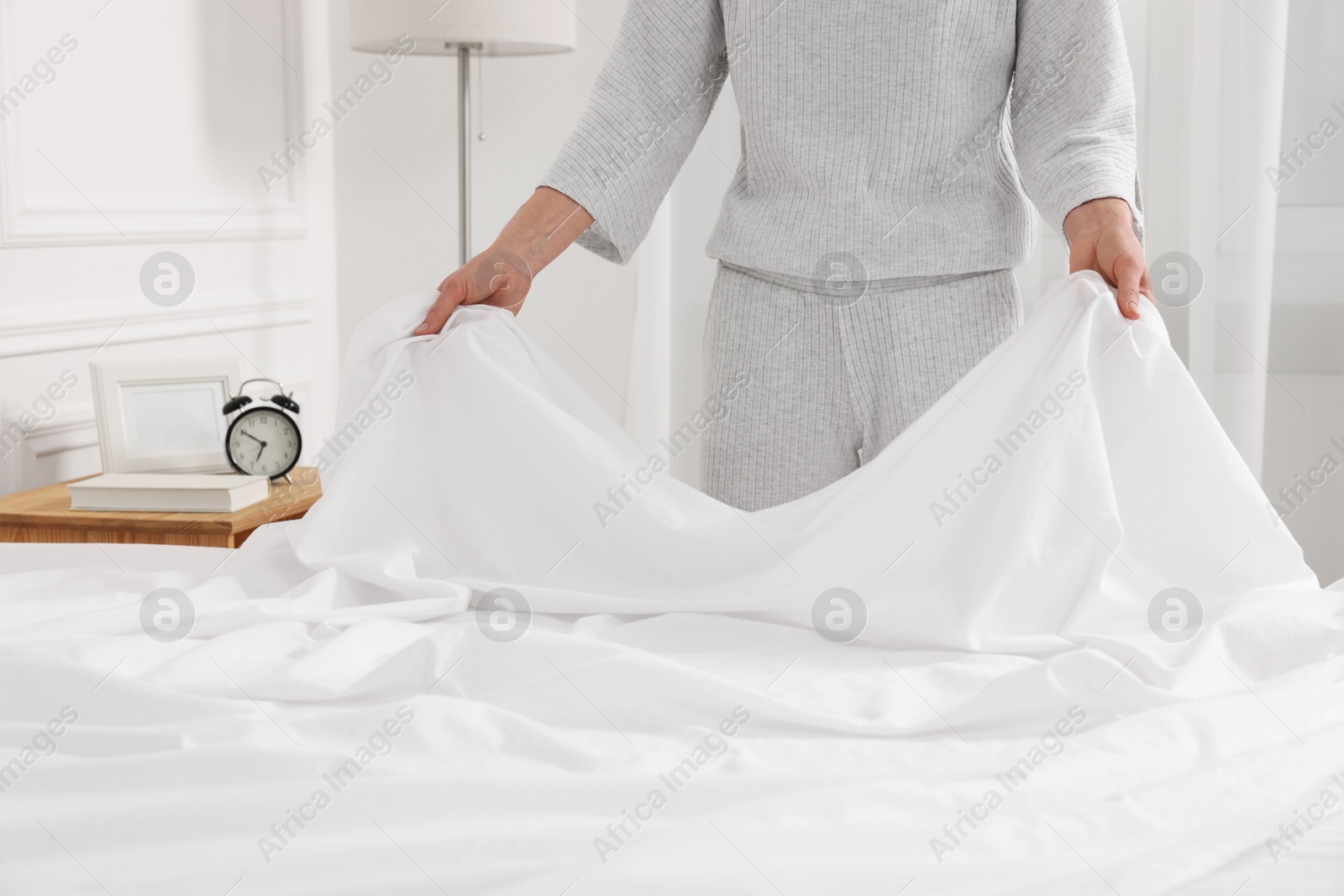 Photo of Woman changing bed linens at home, closeup