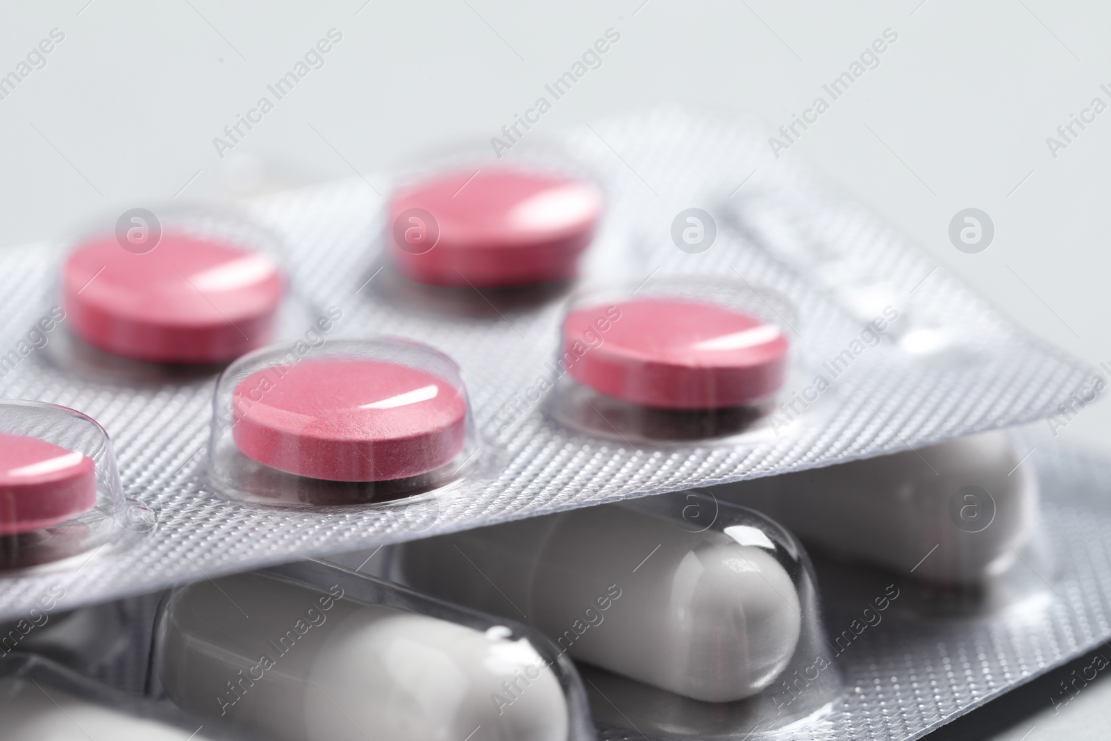 Photo of Different pills in blisters as background, closeup