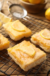 Photo of Tasty lemon bars on wooden table, closeup