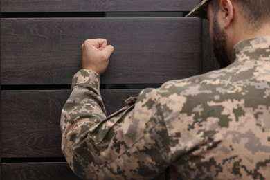 Military commissariat representative knocking on wooden door, closeup