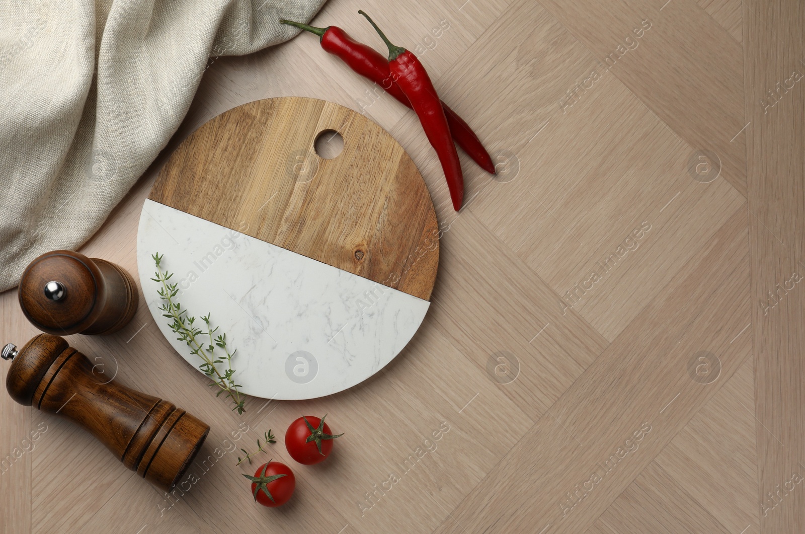 Photo of Cutting board and different spices on wooden table, flat lay. Space for text