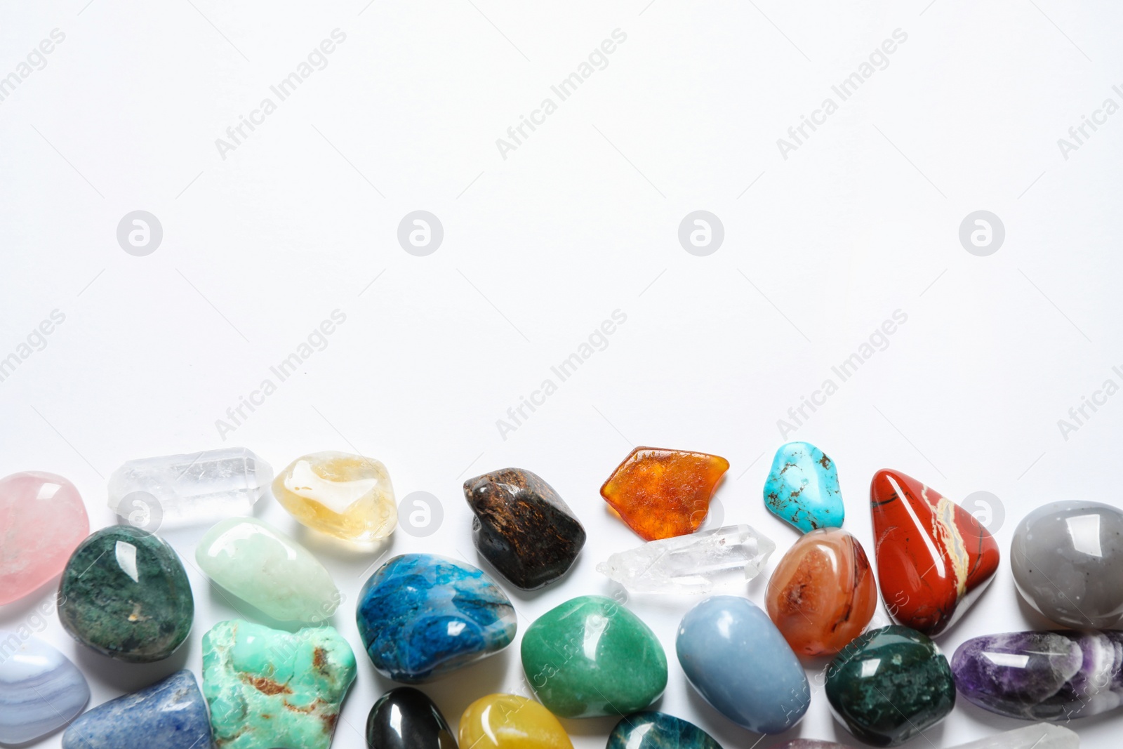 Photo of Different beautiful gemstones on white background, top view