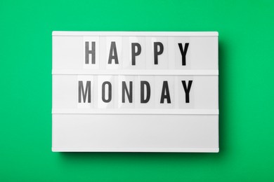 Photo of Light box with message Happy Monday on green background, top view