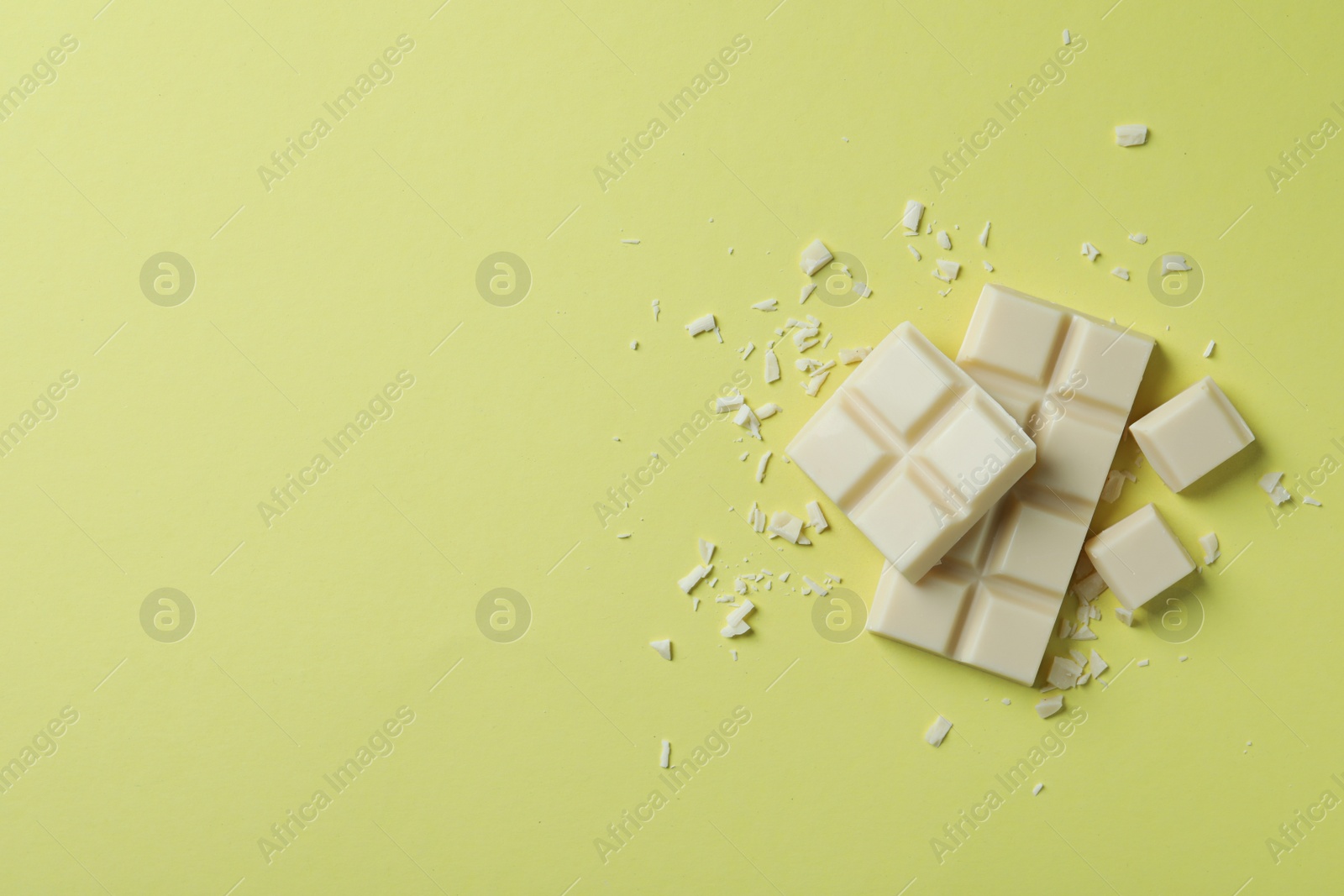 Photo of Tasty white chocolate on yellow background, flat lay. Space for text