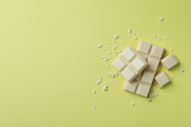 Tasty white chocolate on yellow background, flat lay. Space for text