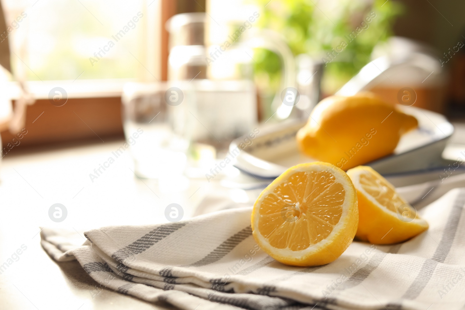 Photo of Halves of fresh ripe lemon on countertop in kitchen, space for text