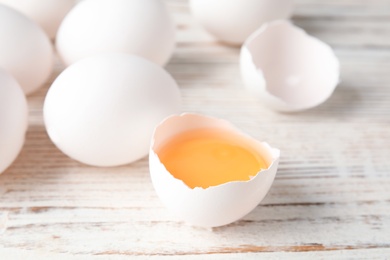 Photo of Few raw chicken eggs on wooden background