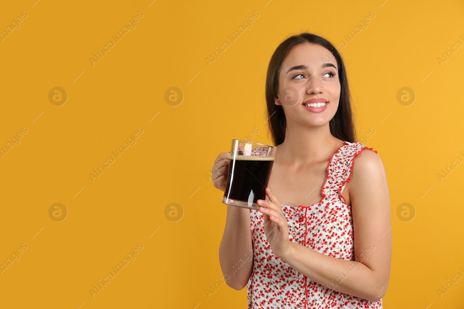 Photo of Beautiful woman with cold kvass on yellow background. Traditional Russian summer drink