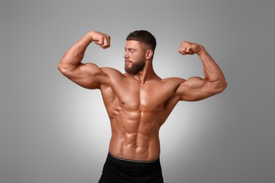 Photo of Young bodybuilder with muscular body on light grey background