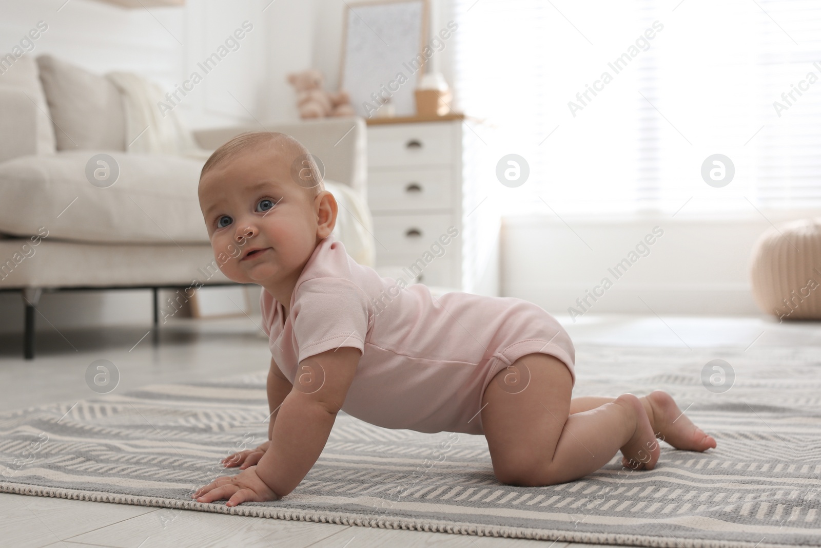 Photo of Cute baby crawling on floor at home