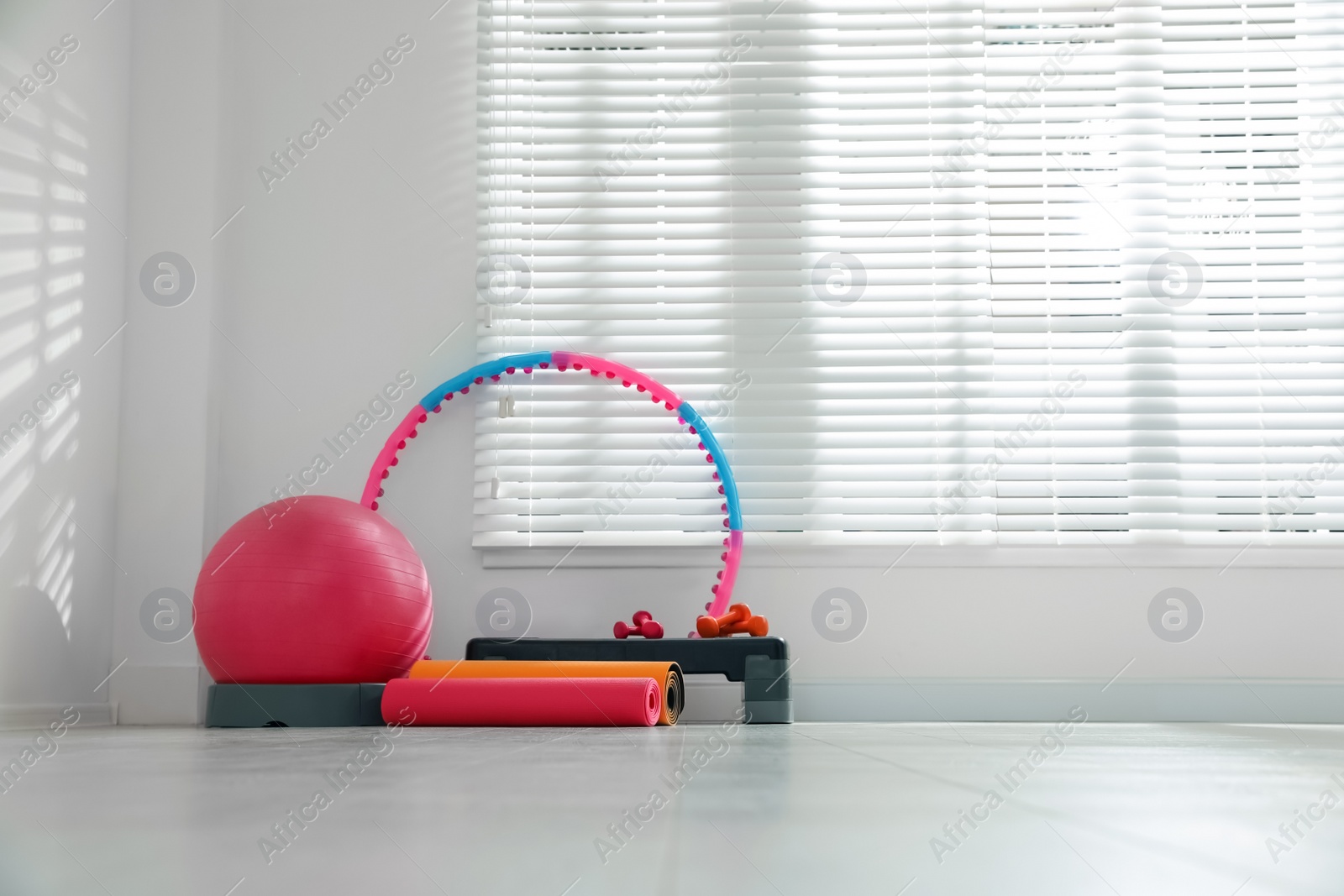 Photo of Different sports equipment near window in gym. Space for text