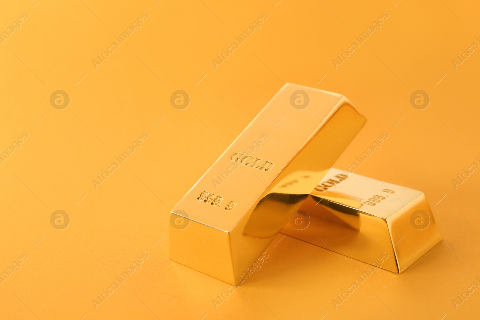 Photo of Precious shiny gold bars on color background. Space for text