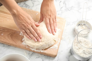 Woman kneading dough for pastry on table