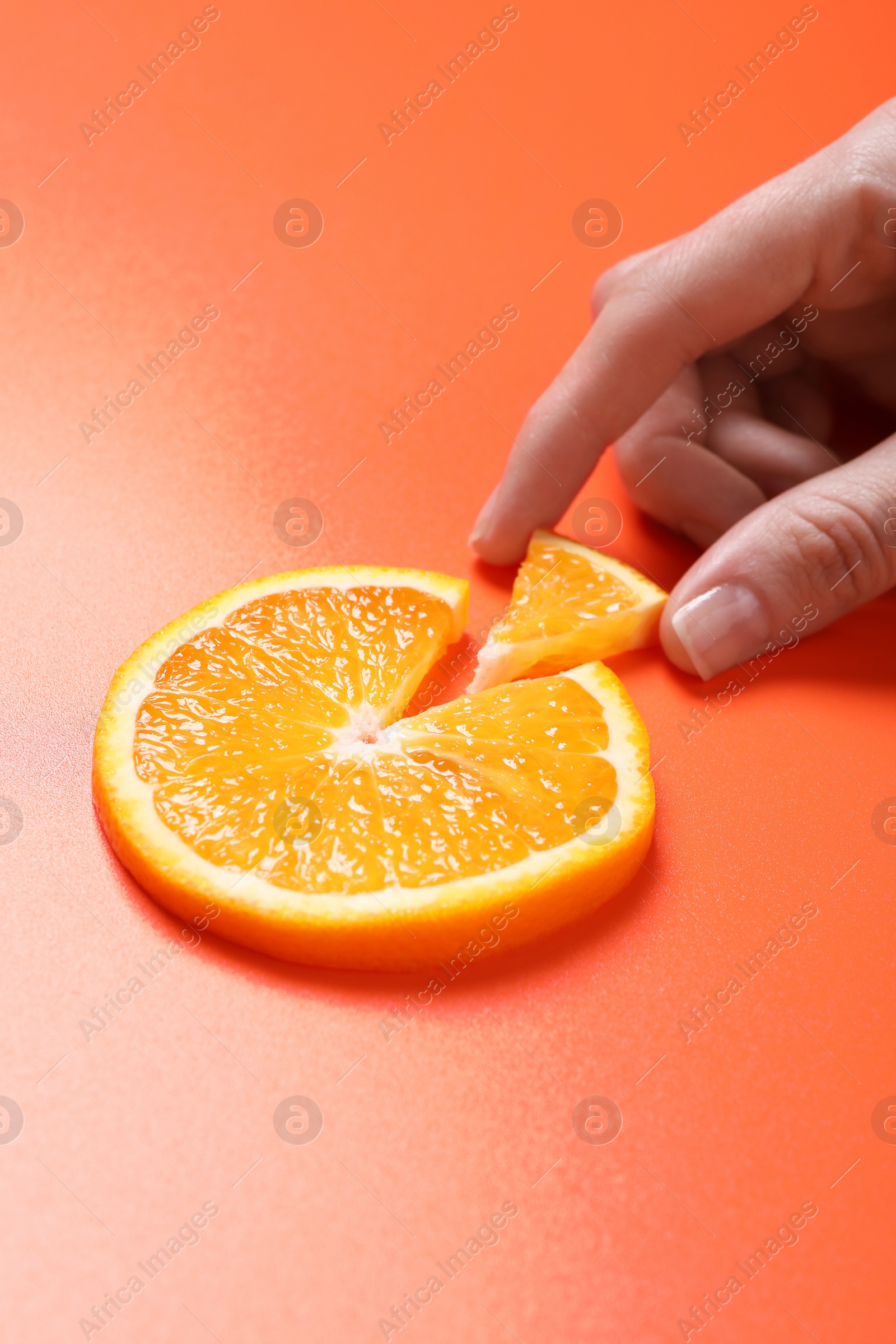 Photo of Woman with slices of juicy orange on terracotta background, closeup