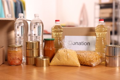 Photo of Volunteering. Different food products and cardboard boxes on table in warehouse
