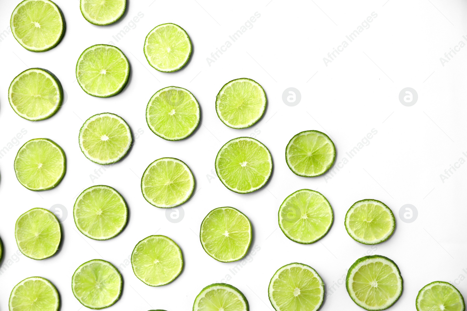 Photo of Slices of fresh juicy limes on white background, flat lay