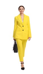 Beautiful businesswoman in yellow suit with briefcase walking on white background